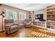 Cozy living room features built-in shelving, wood floors and two large windows at 12493 Forest Canyon Dr, Parker, CO 80138