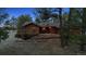 Back exterior view of a home with a sunroom and deck, surrounded by mature trees at 12493 Forest Canyon Dr, Parker, CO 80138