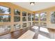 Bright sunroom surrounded by windows showcasing wooded scenery and natural light at 12493 Forest Canyon Dr, Parker, CO 80138