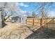 View of the backyard featuring a new wooden fence, detached garage, and partial view of the house at 315 S Xapary St, Aurora, CO 80012