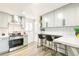 Open kitchen with stainless steel appliances, gray cabinets, a breakfast bar, and subway tile backsplash at 315 S Xapary St, Aurora, CO 80012