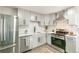 Beautiful kitchen features stainless steel appliances, light grey cabinets, and a white subway tile backsplash at 315 S Xapary St, Aurora, CO 80012