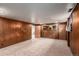 Basement area with wood-paneled walls, carpeted floors, and multiple entryways at 3225 W Mexico Ave, Denver, CO 80219