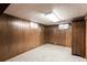 Functional basement with wood paneling, two small windows and neutral carpeting at 3225 W Mexico Ave, Denver, CO 80219