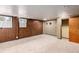 Basement area with wood paneling, carpeting, and a classic patterned accent wall at 3225 W Mexico Ave, Denver, CO 80219