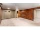 Retro basement featuring classic wood paneling, patterned wallpaper and neutral carpet flooring at 3225 W Mexico Ave, Denver, CO 80219