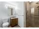 Bathroom featuring a glass-enclosed shower, wood vanity, and toilet at 3225 W Mexico Ave, Denver, CO 80219