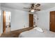 Bright bedroom featuring a ceiling fan and neutral carpet; bathroom and second room in view at 3225 W Mexico Ave, Denver, CO 80219