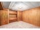 Cozy bedroom featuring wood-paneled walls, built-in storage, and soft carpeting at 3225 W Mexico Ave, Denver, CO 80219