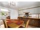 Open dining room featuring wood floors, kitchen view, and bright light at 3225 W Mexico Ave, Denver, CO 80219