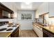 Galley kitchen featuring wood floors, light cabinetry, and modern appliances at 3225 W Mexico Ave, Denver, CO 80219