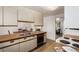 Bright kitchen with stainless steel sink, light cabinets, and views into the dining and living areas at 3225 W Mexico Ave, Denver, CO 80219