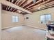 Unfinished basement featuring carpet, two windows, and exposed ceiling beams at 424 N De Gaulle Ct, Aurora, CO 80018