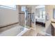 Modern bathroom featuring a soaking tub, glass-enclosed shower, and elegant tile work at 424 N De Gaulle Ct, Aurora, CO 80018