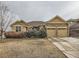 Well-maintained home featuring a two-car garage, stone accents, and landscaped front yard at 424 N De Gaulle Ct, Aurora, CO 80018