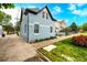 A view of the side of the light-blue two-story home, showcasing the brick construction and landscaping at 1019 26Th St, Denver, CO 80205