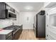Modern kitchen features stainless steel appliances, including refrigerator and gas range, with dark cabinetry and bright countertops at 1019 26Th St, Denver, CO 80205