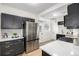 Modern kitchen features stainless steel appliances, including refrigerator and gas range, with dark cabinetry and bright countertops at 1019 26Th St, Denver, CO 80205