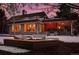 Evening view of home's exterior, fire pit, and snowy backyard at 66 Charlou Cir, Cherry Hills Village, CO 80111