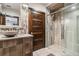 Bathroom featuring modern vanity, decorative mirror, and a glass-enclosed shower at 3219 Castle Butte Dr, Castle Rock, CO 80109