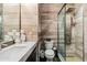 Contemporary bathroom featuring wood-look tile walls and a sleek glass-enclosed shower with modern fixtures at 3219 Castle Butte Dr, Castle Rock, CO 80109