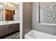 Modern bathroom featuring a bathtub with stylish tile accents, a spacious vanity, and updated fixtures at 3219 Castle Butte Dr, Castle Rock, CO 80109