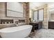 Bright bathroom featuring a large soaking tub, wooden tile and a dark vanity at 3219 Castle Butte Dr, Castle Rock, CO 80109
