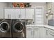 Efficient laundry room with white cabinetry, modern appliances, and organized storage space at 3219 Castle Butte Dr, Castle Rock, CO 80109