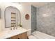 Stylish bathroom featuring blue tiled shower, oval mirror, and wood vanity at 8335 Fairmount Dr # 7-208, Denver, CO 80247