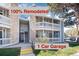Renovated condo building featuring a one-car garage, stone accents, and outdoor stairways with white banisters at 8335 Fairmount Dr # 7-208, Denver, CO 80247