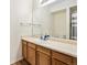 Bathroom vanity featuring wood cabinets, a white countertop, mirror, and a shower with a striped curtain at 912 S Yampa St # 208, Aurora, CO 80017