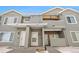 Townhome exterior with gray siding and stone accents with a shared covered entryway with unit numbers and white doors at 912 S Yampa St # 208, Aurora, CO 80017