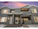 Townhome exterior featuring gray siding, stone accents, and a shared covered entryway with unit numbers under a colorful sunset sky at 912 S Yampa St # 208, Aurora, CO 80017