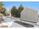 Exterior view of garages and townhomes with snowy ground and evergreens on a sunny day at 912 S Yampa St # 208, Aurora, CO 80017