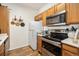 Kitchen features stainless steel appliances, wood cabinets, wood look flooring, and decorative hanging copper pots at 912 S Yampa St # 208, Aurora, CO 80017