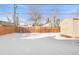 Snowy backyard with wooden fence and storage shed at 185 S Eliot St, Denver, CO 80219