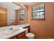 Bathroom features a single sink, wood cabinets, wallpaper, and window with natural light at 8095 Garrison Ct # B, Arvada, CO 80005