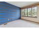 Bedroom features horizontal wood design on blue walls, carpet floors, and a window with natural light at 8095 Garrison Ct # B, Arvada, CO 80005
