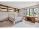 Bedroom features built-in shelving, carpet floors, and a bright window with natural light and a desk at 8095 Garrison Ct # B, Arvada, CO 80005