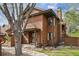 Charming brown two-story home featuring mature trees and professional landscaping at 8095 Garrison Ct # B, Arvada, CO 80005