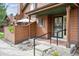 Charming front porch with black metal railing, steps, and space for seating, set in a landscaped yard at 8095 Garrison Ct # B, Arvada, CO 80005