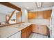 Kitchen featuring classic oak cabinetry, white countertops, and pass-through window to the living room at 8095 Garrison Ct # B, Arvada, CO 80005
