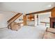 Living room features staircase, leather chair, fireplace, carpet floors, and opening to kitchen at 8095 Garrison Ct # B, Arvada, CO 80005