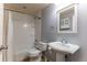 Basement bathroom with a tub, pedestal sink, and mirror at 9112 E 29Th Pl, Denver, CO 80238