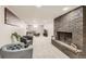 Spacious basement living area with a brick fireplace, plush gray carpet, and comfortable seating at 7604 Reed St, Arvada, CO 80003