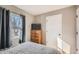 Relaxing bedroom featuring a wooden dresser, large window with curtains, and closet at 7604 Reed St, Arvada, CO 80003
