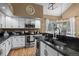 Bright kitchen features white cabinets, granite counters, updated stainless appliances, and a modern lighting fixture at 8051 W 78Th Cir, Arvada, CO 80005