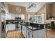 Bright kitchen features white cabinets, granite counters, updated stainless appliances, and a modern lighting fixture at 8051 W 78Th Cir, Arvada, CO 80005
