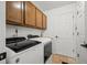 Practical laundry room equipped with modern washer and dryer, storage cabinets, and convenient access to the home at 8051 W 78Th Cir, Arvada, CO 80005