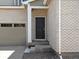 Home entrance featuring a dark door, brick facade, and gray gravel landscaping at 552 Red Rock Pl, Brighton, CO 80601